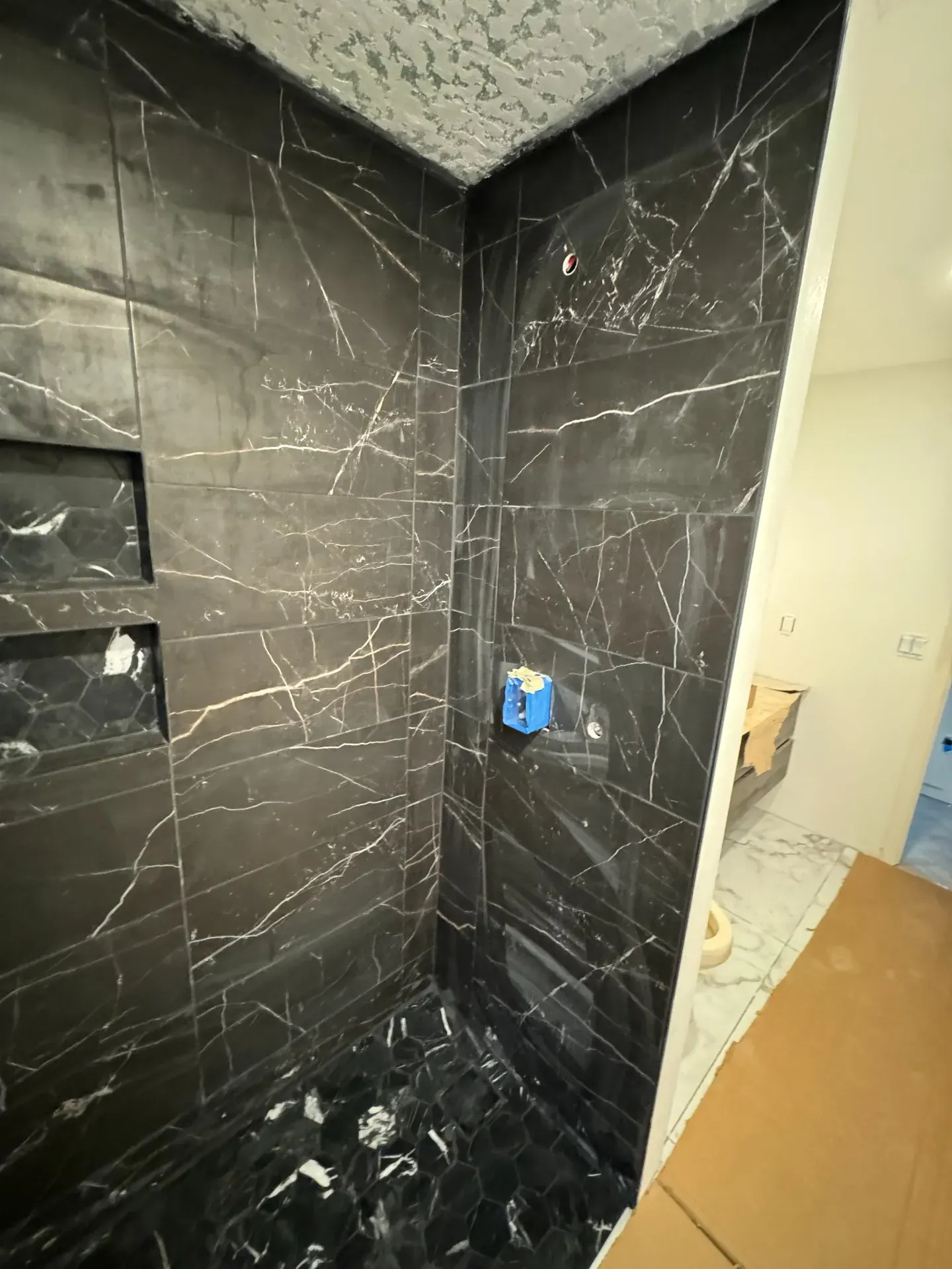 Black tiled shower wall and plumbing locations